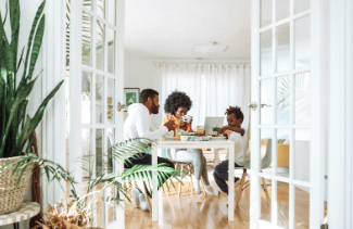 A family sitting at a table together in their home